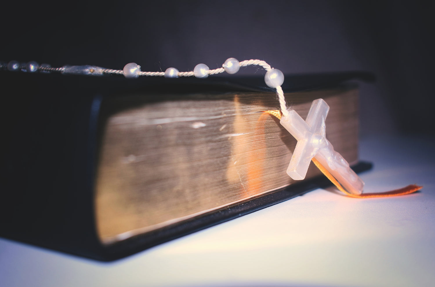 A rosary resting on a bible.